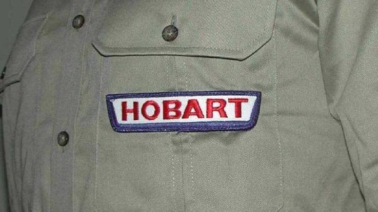 Billede af en skjorte med et broderet Hobart-logo på brystlommen.