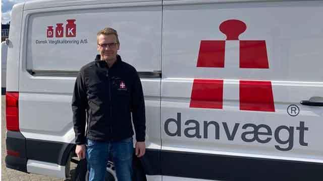 Mand står ved siden af en varevogn med logoet for Danvægt og Dansk Vejgodstransport A/S.