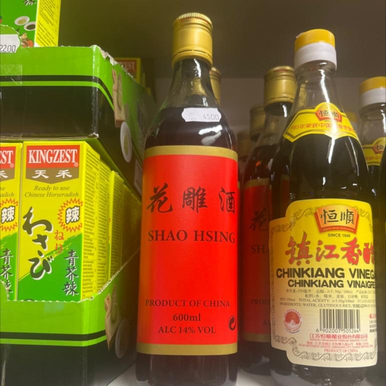Flasker med Shao Hsing risvin og Chinkiang eddike på en hylde i en butik.