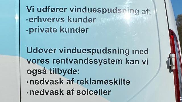 Vinduesskilt med information om vinduespudsning for erhvervs- og private kunder samt yderligere tjenester.