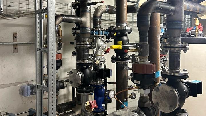 Billede af et rørledningssystem med ventiler og måleinstrumenter i en teknisk installation.