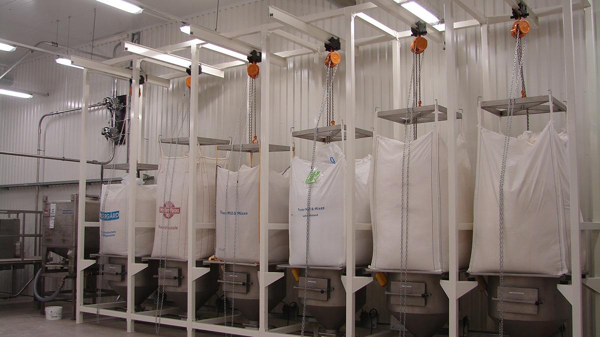 Bags med forskellige ingredienser hængende i en moderne produktionshal.