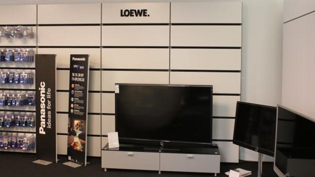 Et moderne tv-display med Loewe og Panasonic tv-apparater i en elektronikbutik.