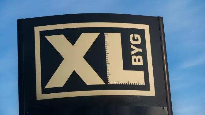 XL BYG skilt med sort baggrund og guldtekst, der viser en måleskala.