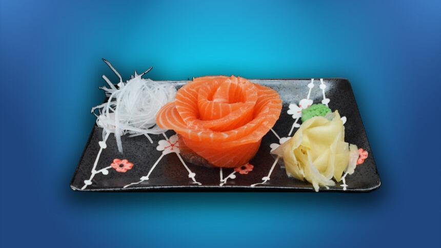 En tallerken med sushi, der viser en roset af laks, wasabi og ingefær, prydet med strimler af radise.