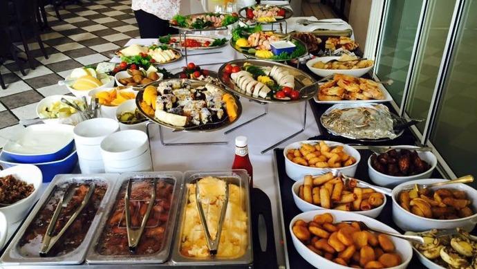 Et overdådigt buffetbord med forskellige retter, herunder salater, fisk, kød og desserter.