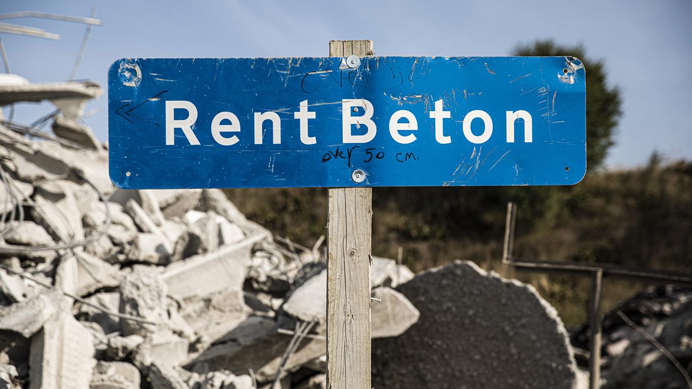Skilt med teksten "Rent Beton" foran en bunke af nedbrudt beton.