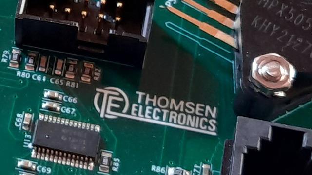 Printplade med Thomsen Electronics logo og komponenter som modstande og kredsløb.