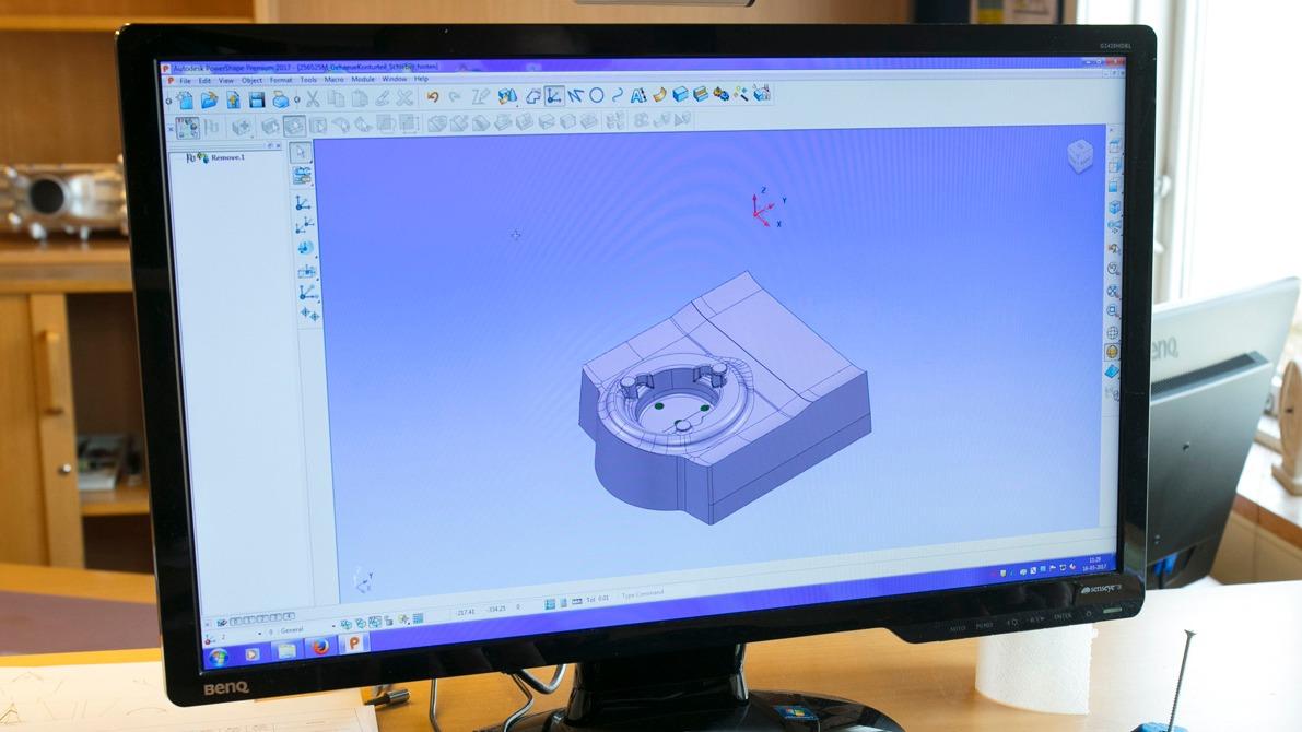 En computerskærm viser en 3D-model af en mekanisk komponent i designsoftware.