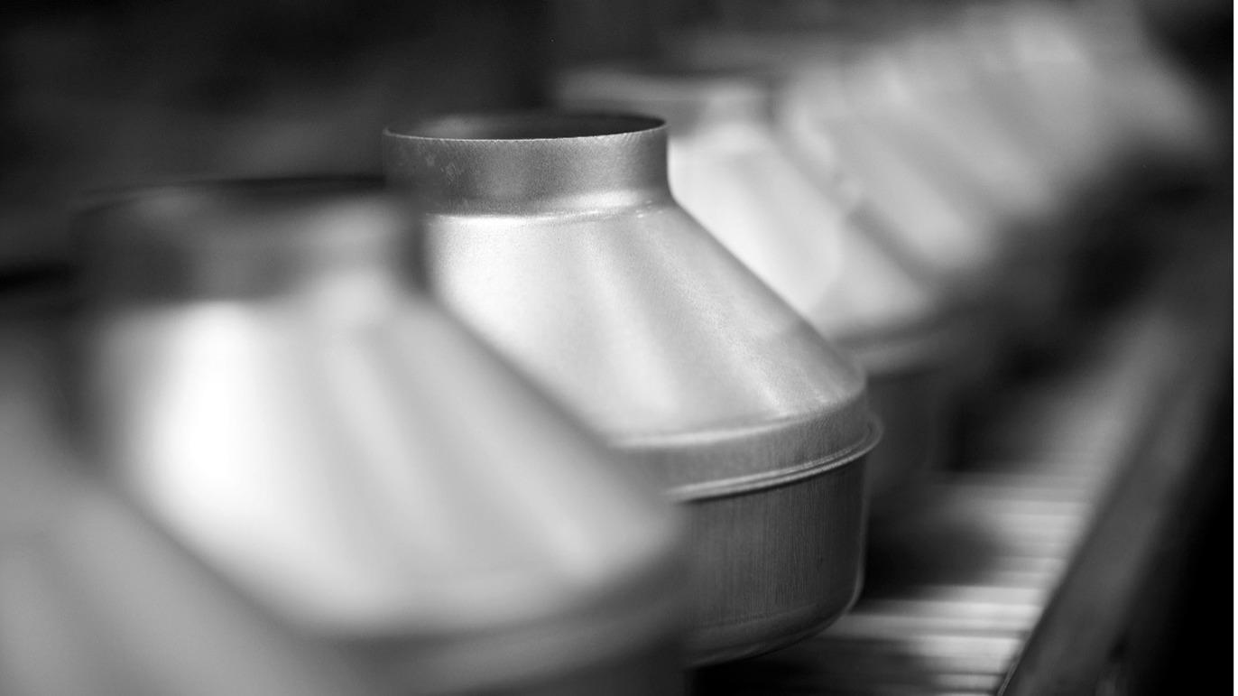 Sorte og hvide metalforme i en række, der står klar til brug i et køkken.