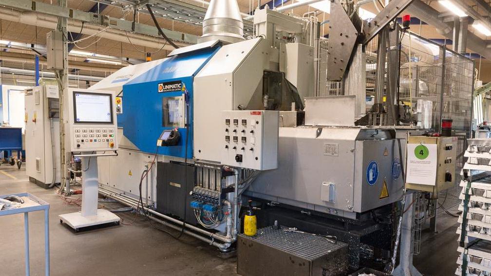 Industriel maskine i en fabrik med kontrolpanel og rørledninger, der bruges til produktion.
