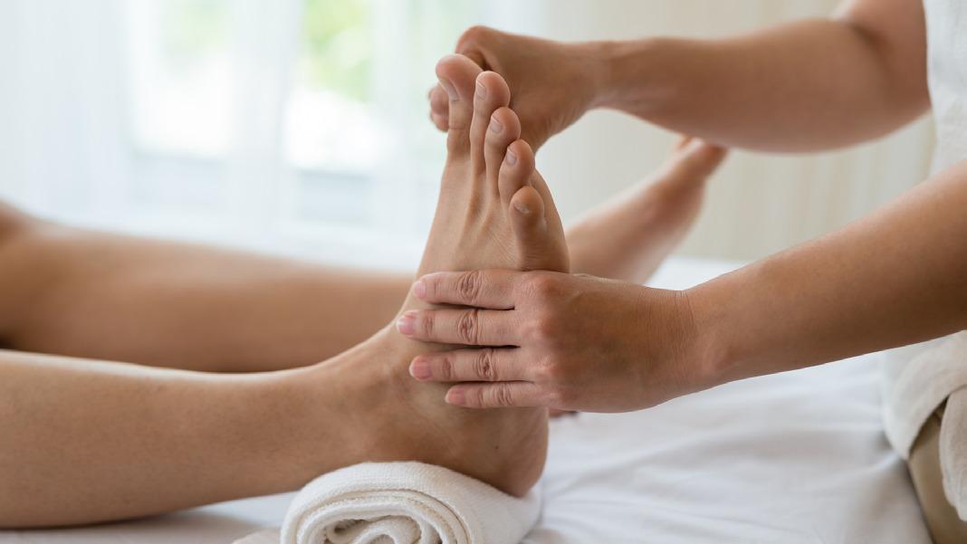 Fodmassage i en afslappende atmosfære med en terapeut, der arbejder på en klients fødder.