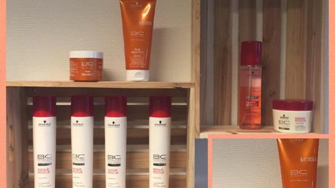 Billede af hylder med forskellige hårplejeprodukter, herunder shampoo, balsam og stylingcreme i orange og hvid emballage.