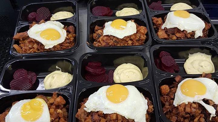 Måltider med stegte æg, kartoffeltern og rødbeder, serveret med mayonnaise i sorte plastikbakker.