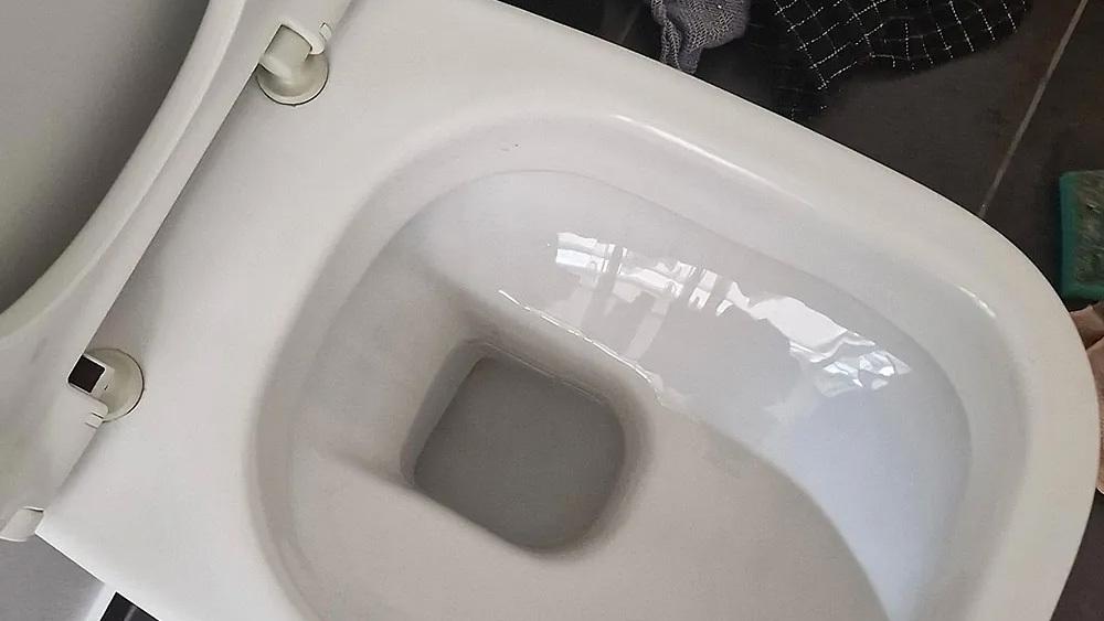 Et rent toilet med hvid skål set ovenfra, uden vand i.