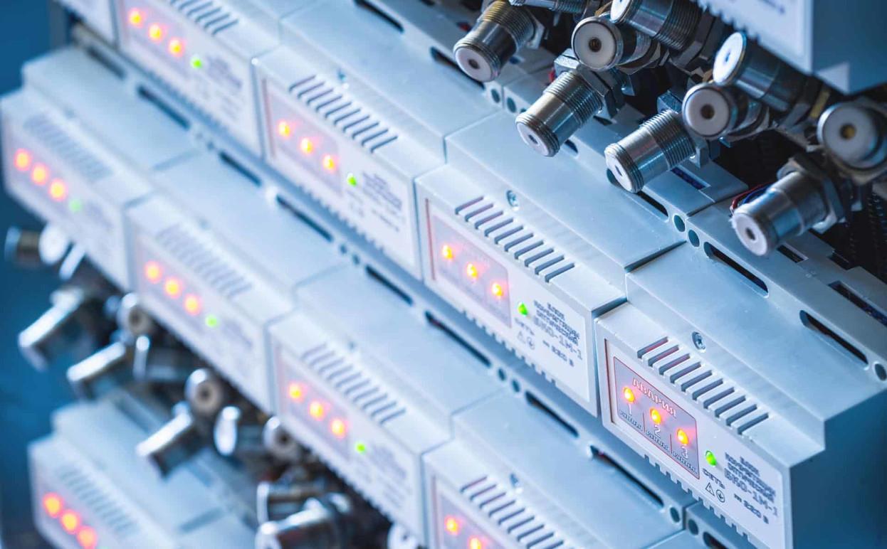 En række elektroniske enheder med lysdioder og tilslutninger i et teknisk miljø.