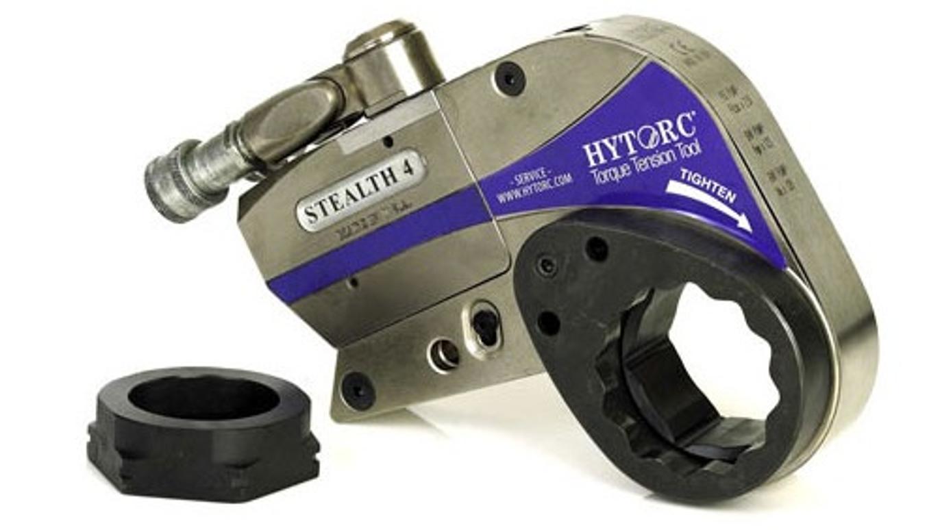 En HYTORC Stealth 4 hydraulisk spændingsværktøj med en sort adapter ved siden af.