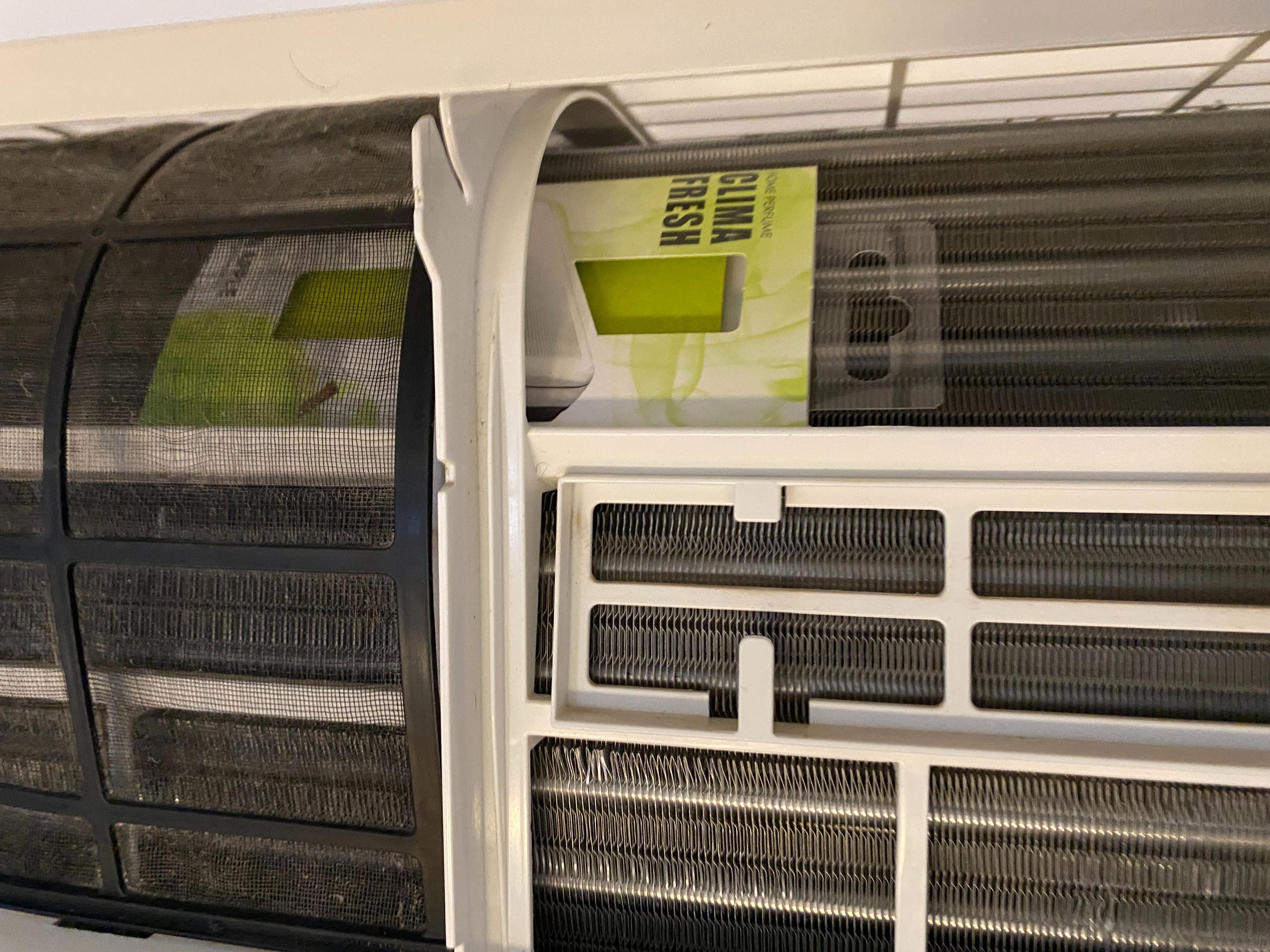 Billede af en airconditionenhed med en advarsel om vedligeholdelse synlig på fronten.