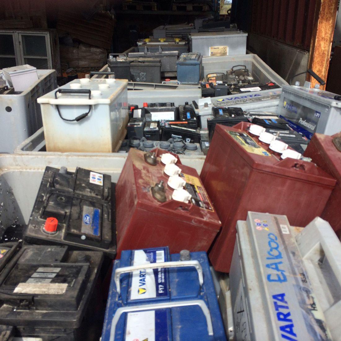 Batterier i forskellige størrelser og typer stablet i en container, klar til genbrug eller bortskaffelse.