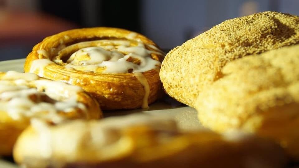 Lækre kanelstænger og en gylden bolle med sukker på en tallerken.