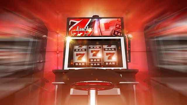 En farverig spillemaskine med tre hjul, der viser symboler som 7'ere og BAR, i et lysende casino-miljø.