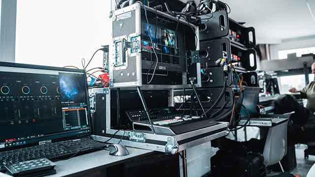 Et moderne videoproduktionssetup med computere, skærme og udstyr til live streaming.