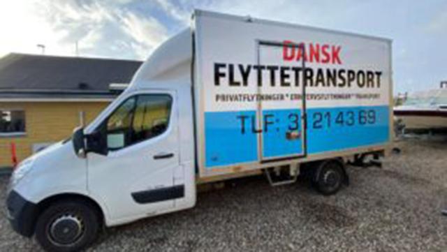 En flyttebil med teksten "DANSK FLYTTETRANSPORT" står parkeret på en grusvej.