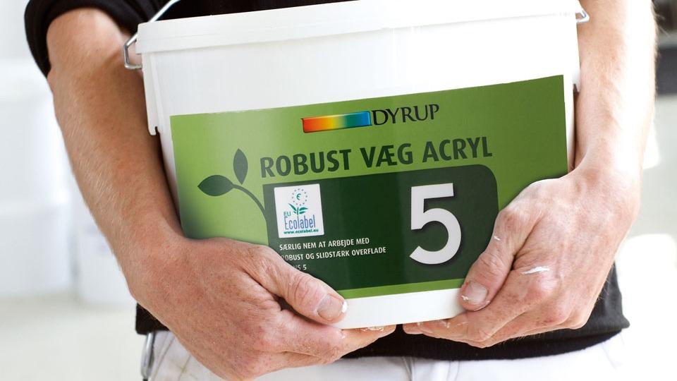 En person holder en spand med DyRUP Robust Væg Acryl maling i hænderne.