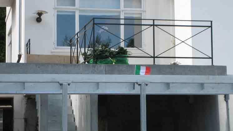 Et hus med en balkon og en italiensk flag på muren under balkonen.