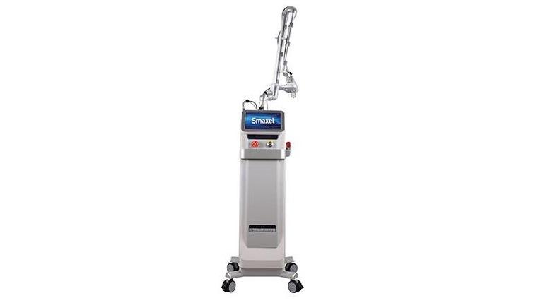En moderne laserbehandlingsmaskine med justerbar arm og digital skærm, placeret på hjul.