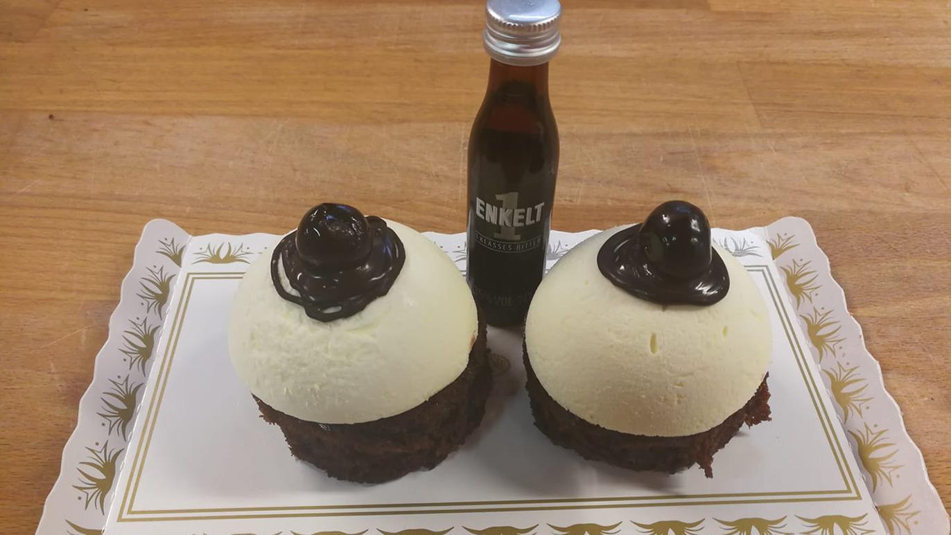 To storeboller med vaniljeis og chokoladeglasur samt en flaske chokolade sauce.