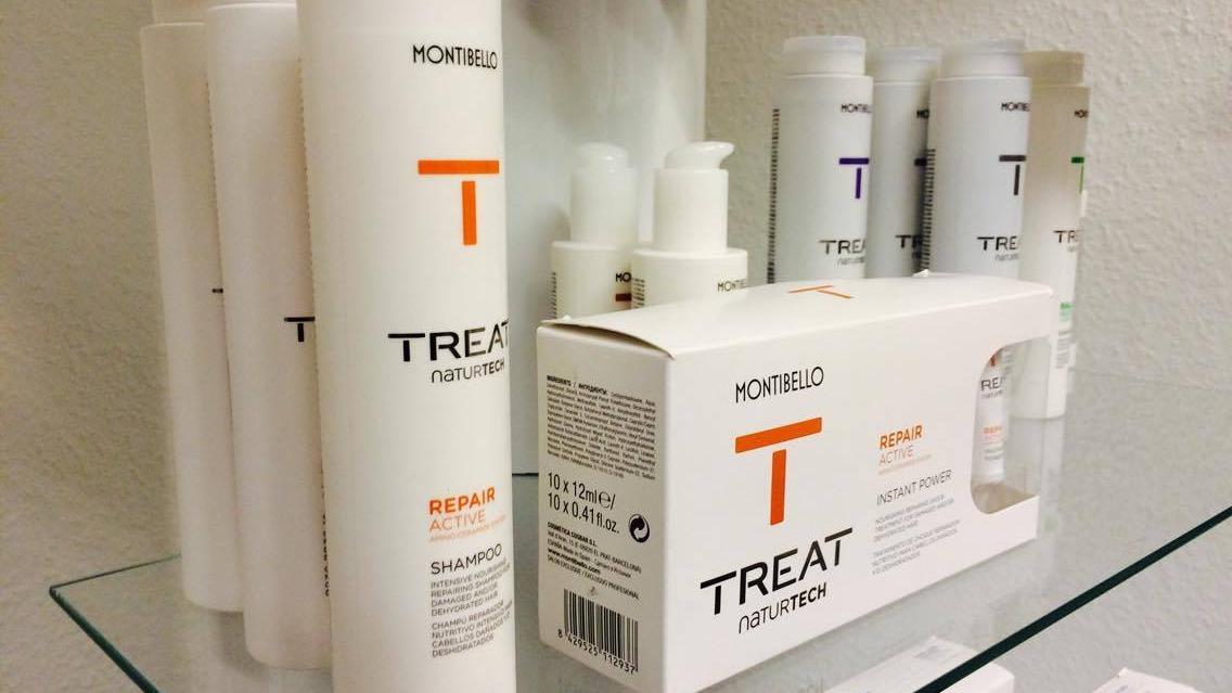 Flasker og emballage af hårplejeprodukter fra mærket MONITUL2 TREAT på en hylde.