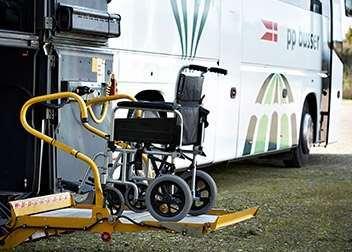 En handicapvenlig bus med en rampe til en kørestol, der står klar til at blive kørt ind.