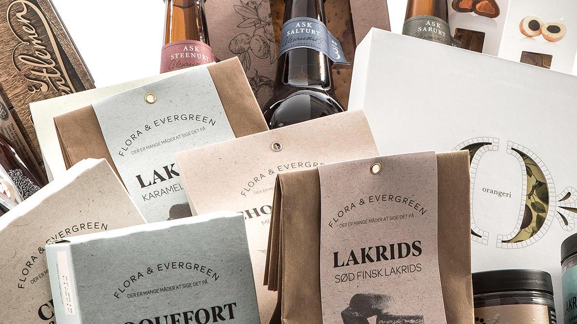Billede af forskellige gourmetprodukter, herunder lakrids, vin og chokolade, præsenteret i æstetisk indpakning.