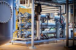 Industrielt anlæg med rør, pumper og udstyr til vandbehandling i en moderne fabrik.