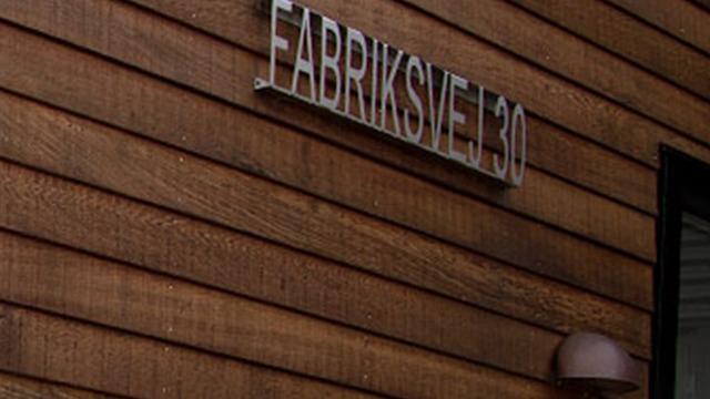 Fabriksv ej 30 skilt på en trævæg, der viser adressen til en bygning.