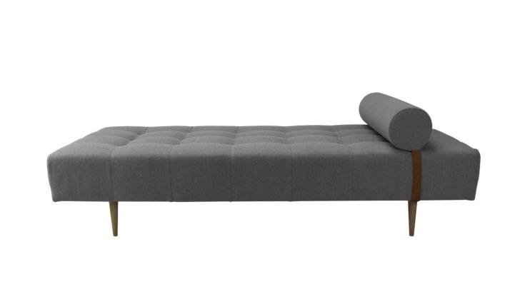 En moderne grå daybed med en rund pude og træben, der giver et stilrent udtryk.