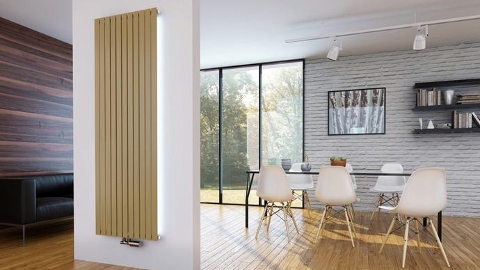 Moderne stue med en gylden radiator, et spisebord og stole, samt store vinduer med udsigt til haven.