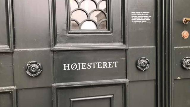 Dør til Højesteret med dekorative detaljer og sort maling.