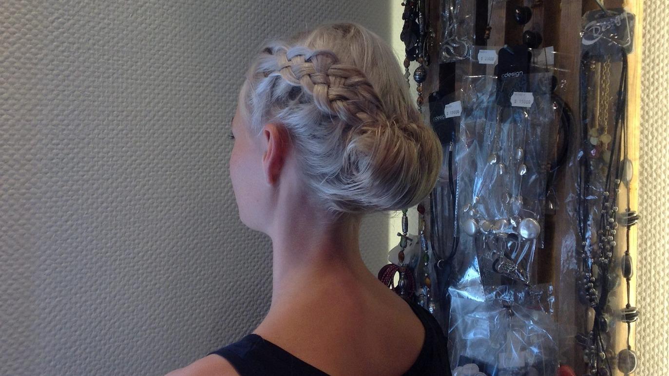 En kvinde med en elegant opsætning af lyst hår og fletninger set bagfra.