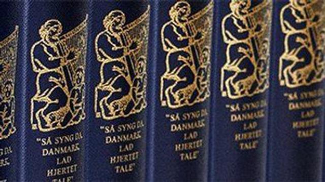 Bøger med guldtryk og illustrationer af en mand med en lyre, titlen "Så syng du Danmark".
