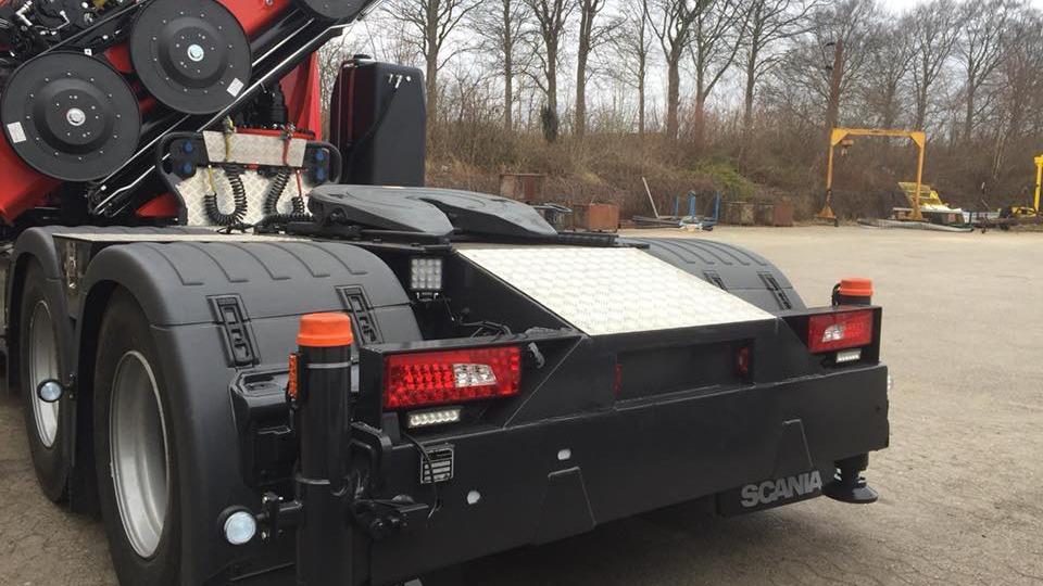 Bagsiden af en Scania lastbil med synlige dæk og lys i en parkeret position.