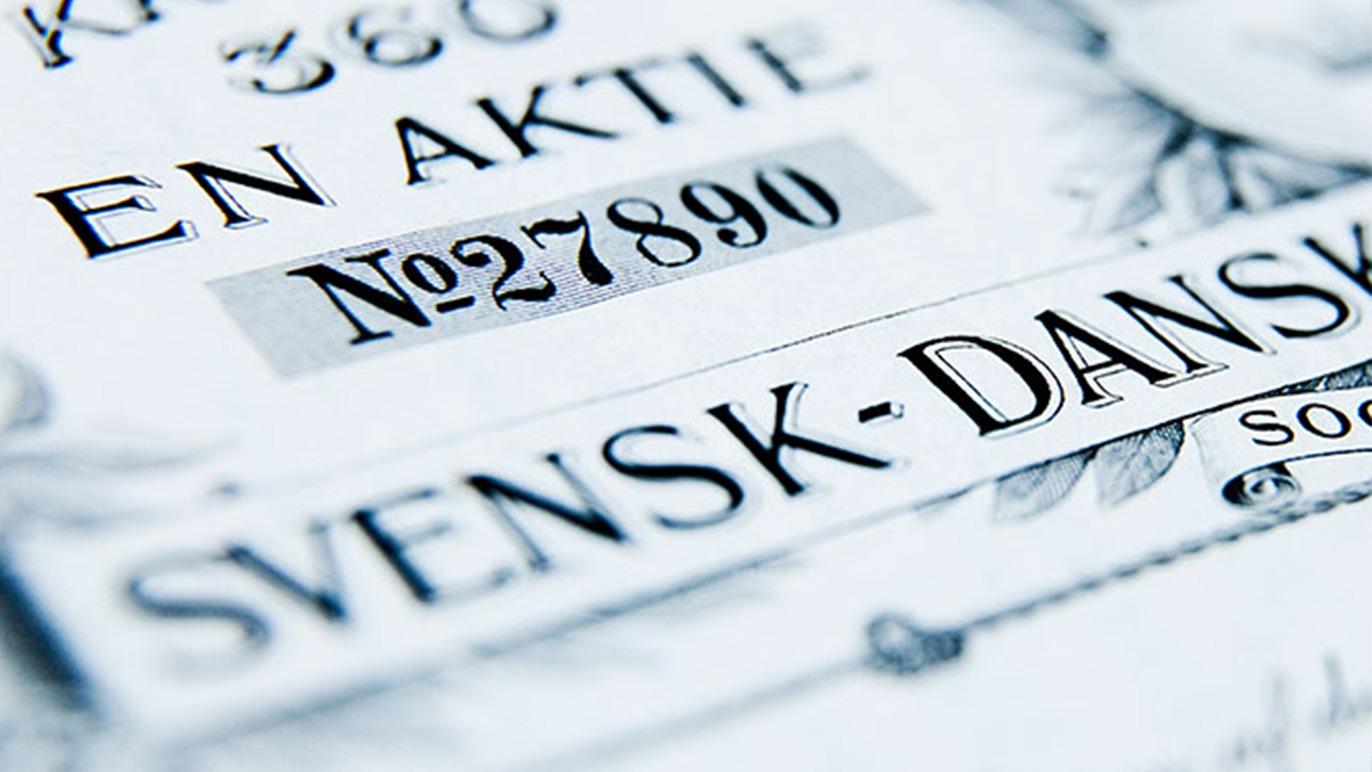 Nærbillede af en aktie med teksten "SVENSK-DANSK" og nummeret "N°27890" synligt.