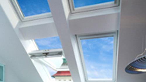 Lys og moderne loftvinduer, der giver udsigt til en blå himmel med skyer.