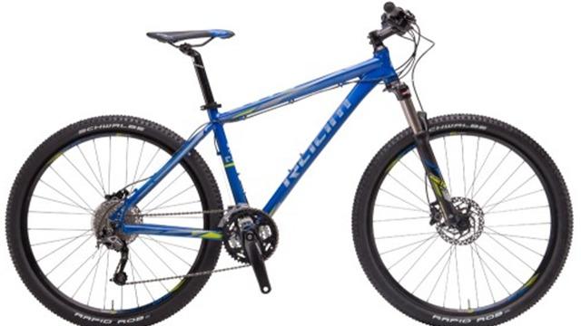 En blå mountainbike med brede dæk og affjedret forgaffel, ideel til terræncykling.