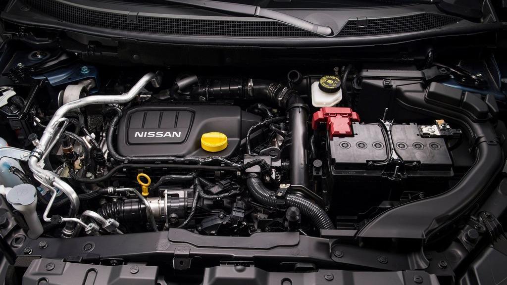 Billede af en Nissan bilmotor med detaljer som oliekran, batteri og kølesystem.