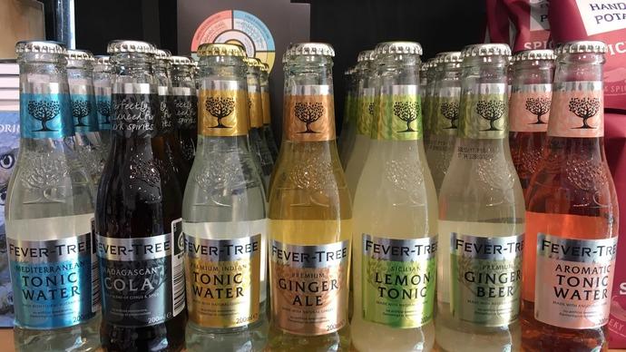 Flere flasker af Fever-Tree tonicvand og ingefærøl i forskellige smagsvarianter på en hylde.