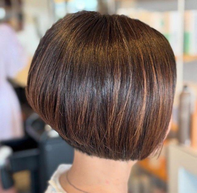 En elegant bob-frisure med glat, skinnende hår i en varm brun nuance.