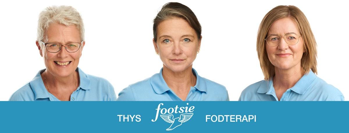 Tre kvinder i blå skjorter smiler, med "Thys Footsie Fodterapi" logoet i bunden af billedet.