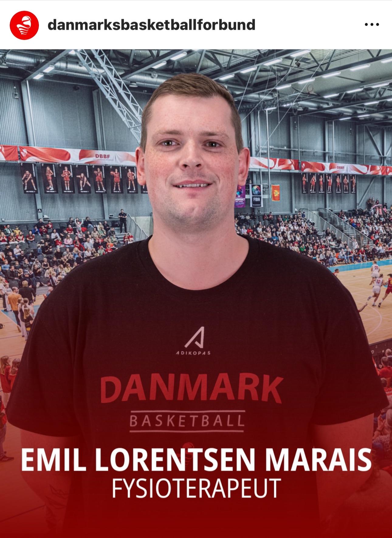 En mand står foran en basketballbane med en stor baggrund af spillere og tilskuere. Han hedder Emil Lorentsen Marais og er fysioterapeut.